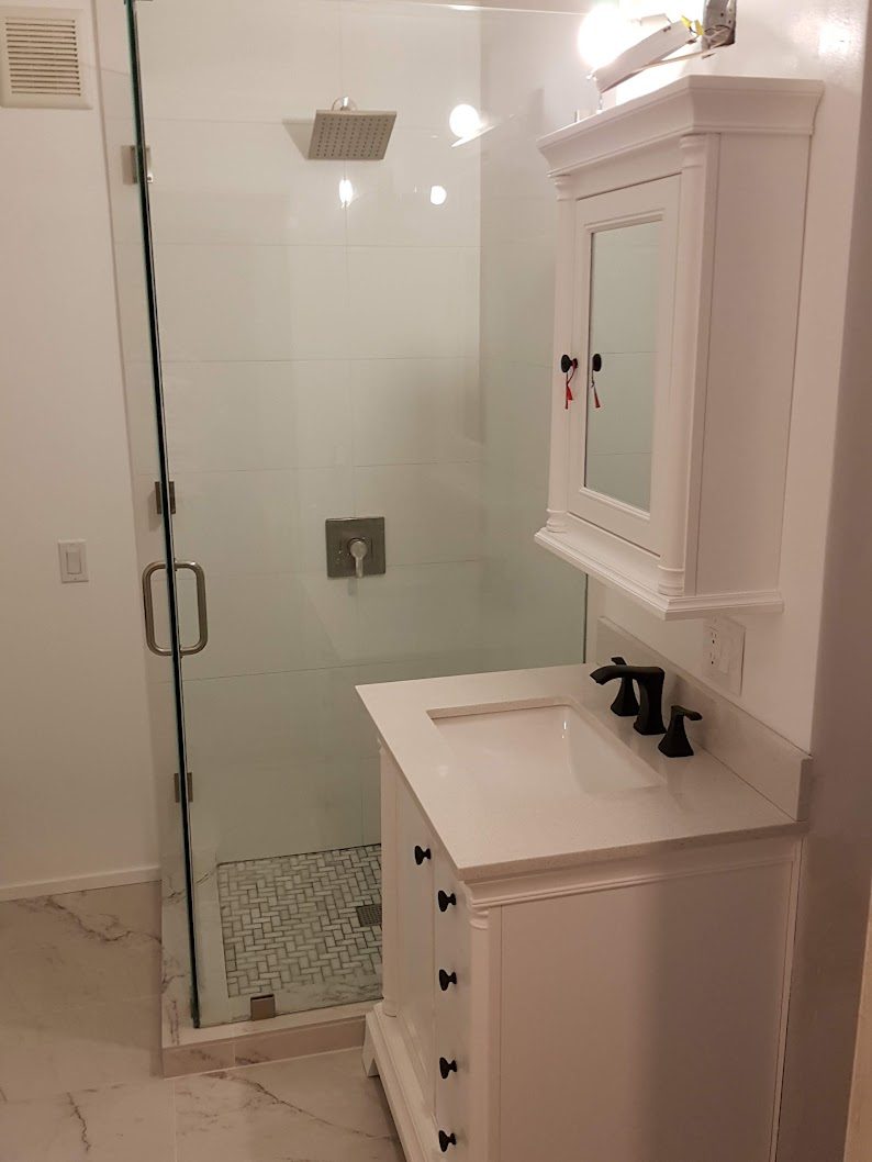 Finished bathroom with frameless glass shower and white vanity