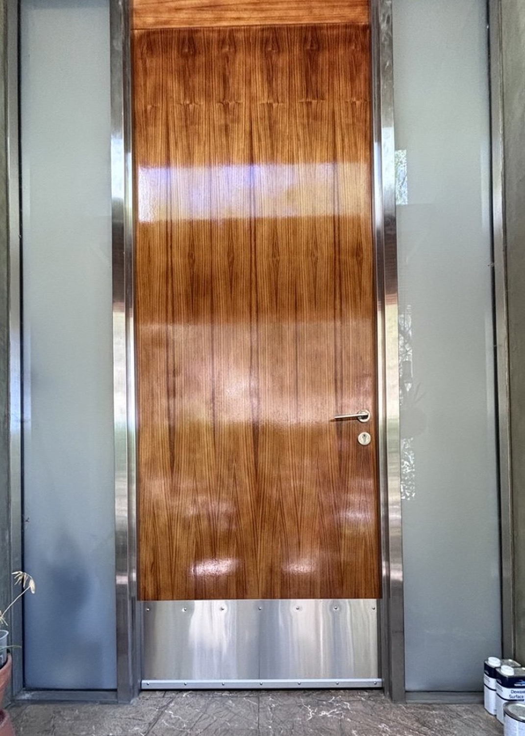 The same entry door refinished, grain restored to a deep amber