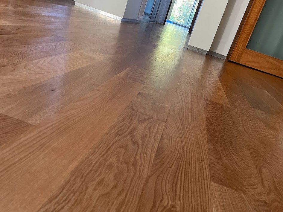 Finished floor running the length of the open room toward the door