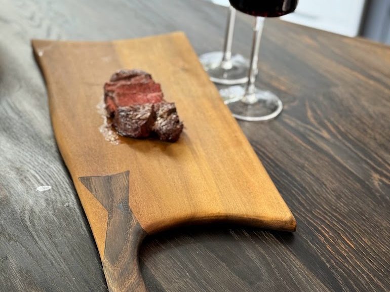 Finished live-edge serving board laid on a table
