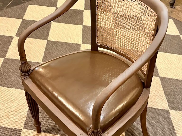 The restored cane armchair with a new leather seat
