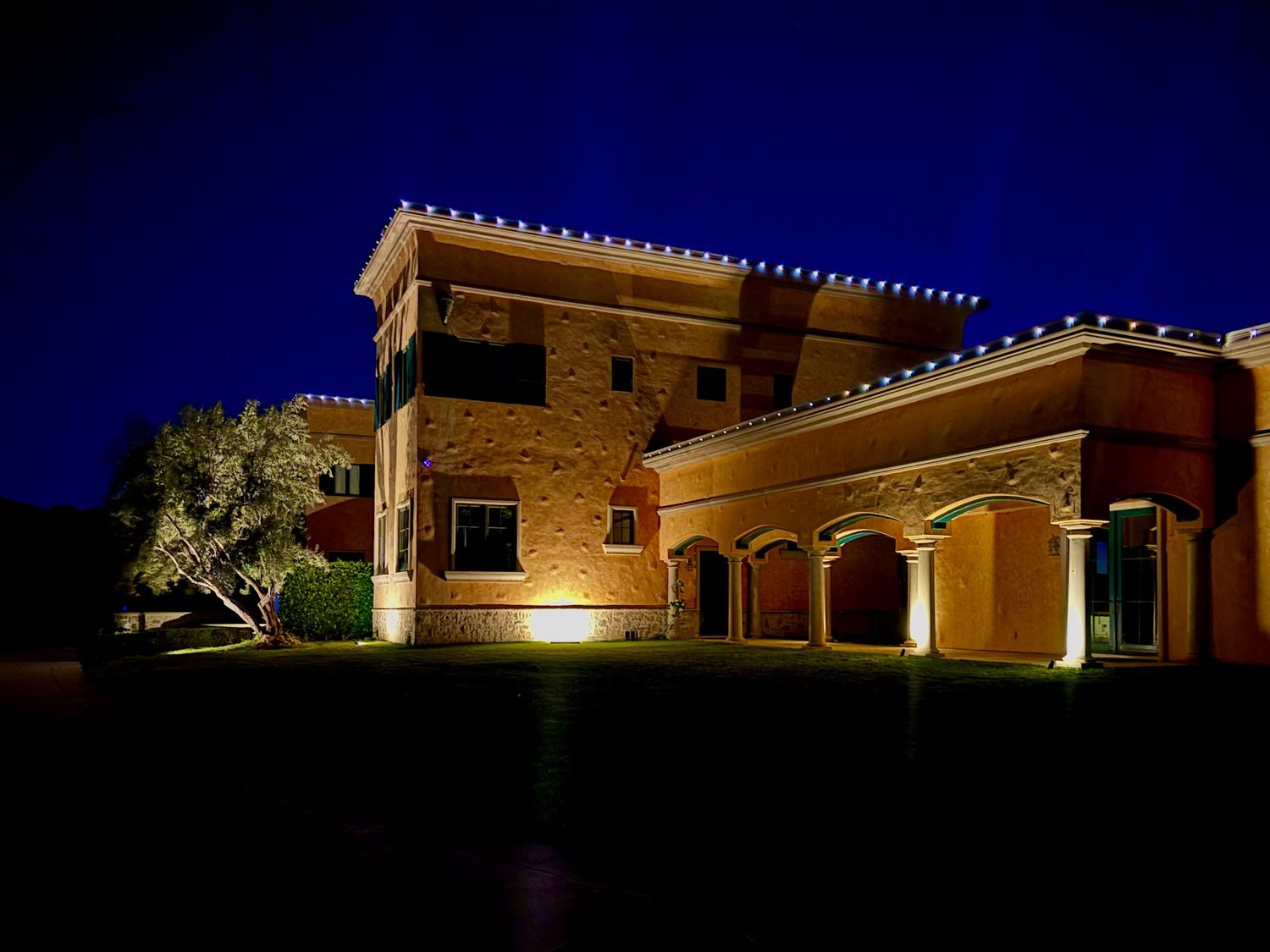 Estate elevation lit at dusk with roofline and uplighting